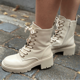 Beige combat boots on a stone pavement